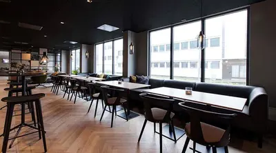 a restaurant with a row of tables and chairs at Scandic Victoria Florø in Florø