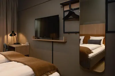 a hotel room with two beds and a flat screen tv at Quality Hotel Grand Steinkjer in Steinkjer
