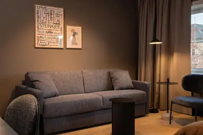 a living room with a couch and a window at Quality Hotel Grand Steinkjer in Steinkjer