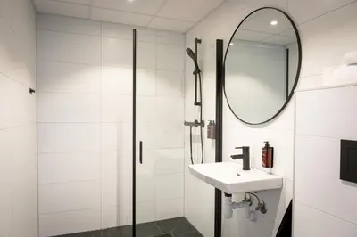 a white bathroom with a sink and a mirror at Quality Hotel Grand Steinkjer in Steinkjer