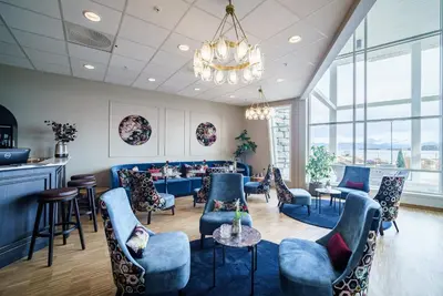 a restaurant with blue chairs and tables and a chandelier at Molde Fjordhotell - by Classic Norway Hotels in Molde