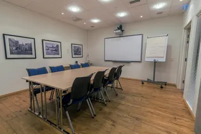 a conference room with a table and chairs and a white screen at Molde Fjordhotell - by Classic Norway Hotels in Molde