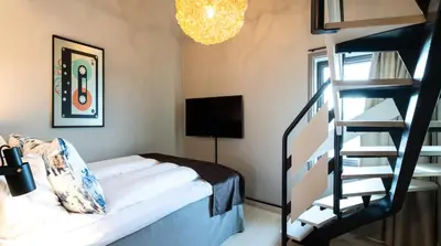 a bedroom with a bunk bed and a spiral staircase at Quality Hotel Panorama in Trondheim