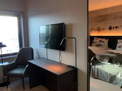 a room with a tv and a bed and a chair at Quality Hotel Panorama in Trondheim