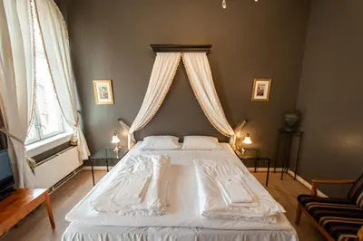 a bedroom with a large white bed with a canopy at Grand Hotel Hønefoss in Hønefoss