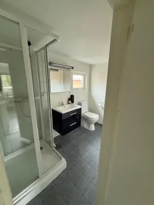 a bathroom with a shower and a sink and a toilet at Grand Hotel Hønefoss in Hønefoss