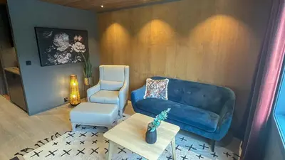 a living room with a blue couch and a chair at Trysil-Knut Hotel in Trysil