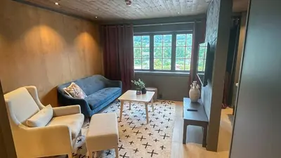 a living room with a blue couch and a table at Trysil-Knut Hotel in Trysil