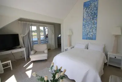 a bedroom with a bed and a tv and a chair at Sunde Fjord Hotel, free and easy parking in Solavagen