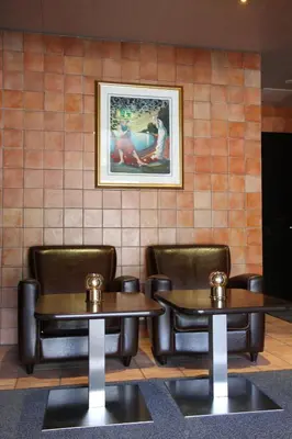 two tables and chairs in a restaurant with a picture on the wall at Fanitullen Hotel in Hemsedal