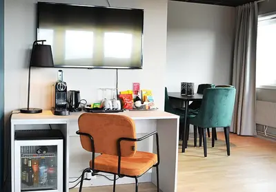 a kitchen with a desk with a chair and a table at Thon Hotel Central in Elverum