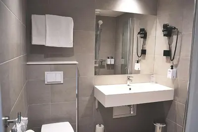 a bathroom with a sink and a toilet at Thon Hotel Central in Elverum