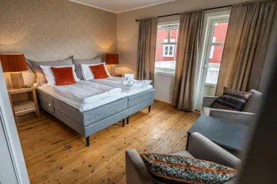 a hotel room with a bed and a couch at Dragsvik Fjordhotel in Balestrand
