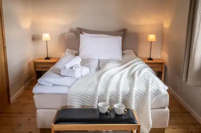 a bedroom with a bed with towels on it at Dragsvik Fjordhotel in Balestrand