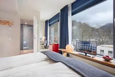 a bedroom with a bed and a large window at Zander K Hotel in Bergen