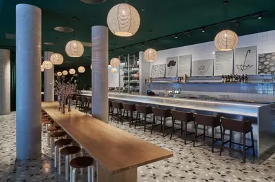 a restaurant with a long bar with chairs and lights at Zander K Hotel in Bergen