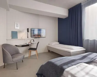 a hotel room with a bed and a chair at Zander K Hotel in Bergen