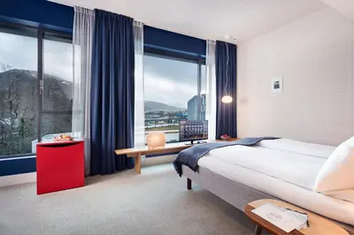 a bedroom with a large bed and a large window at Zander K Hotel in Bergen