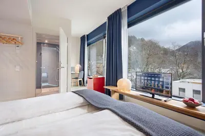 a bedroom with a bed and a large window at Zander K Hotel in Bergen