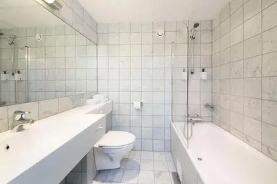 a bathroom with a toilet and a tub and a sink at Scandic Parken in Ålesund