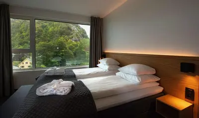 a hotel room with a bed with a large window at Scandic Parken in Ålesund