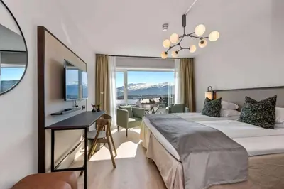 a bedroom with a bed and a desk with a television at Scandic Parken in Ålesund