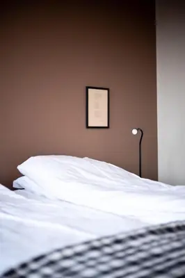 a bedroom with a white bed with a picture on the wall at Askvoll Fjordhotell in Ask