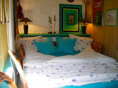 a bed with blue and white pillows in a room at Annehelenes B&B in Bergen