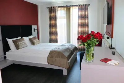 a bedroom with a bed and a vase of red roses at Tynset Hotel in Tynset