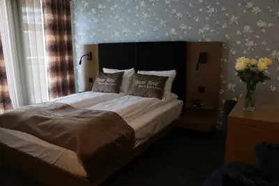 a bedroom with a bed with a vase of flowers at Tynset Hotel in Tynset