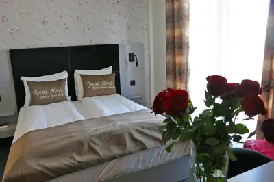 a bedroom with a bed with a vase of red roses at Tynset Hotel in Tynset