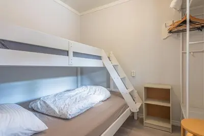 a bedroom with a bunk bed with a ladder at Sotra Rorbusenter in Kåravika