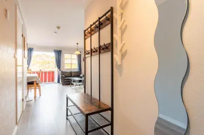 a hallway with a mirror and a table in a room at Sotra Rorbusenter in Kåravika