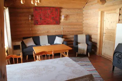 a living room with a couch and a table and chairs at Fosheim Hytter in Ron