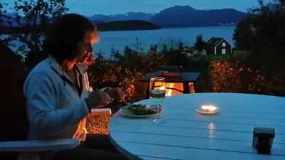 a woman sitting at a table with a plate of food at Nicoll-huset in Ølve