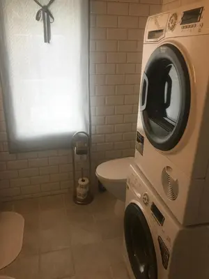a washing machine in a bathroom with a toilet at Nicoll-huset in Ølve
