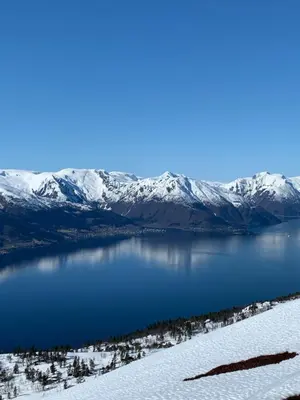 a view of a lake with snow covered mountains at Blix Hotel in Vikøyri