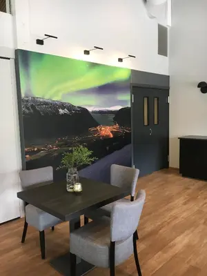 a dining room with a table and chairs with a painting at Blix Hotel in Vikøyri