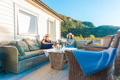 two women sitting on the porch of a house at Strandheimen Guesthouse in Melhus