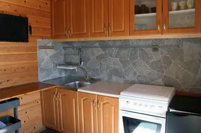 a kitchen with wooden cabinets and a sink and a stove at Tustna Ladestasjon in Hals