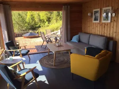 a living room with a couch and a table and chairs at Tustna Ladestasjon in Hals