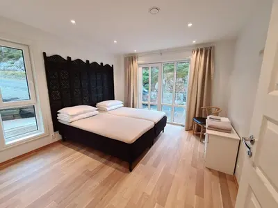 a bedroom with a bed with white sheets and two pillows at Ropeid Villa Fjordferie in Ropeid