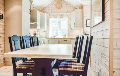a dining room and kitchen with a table and chairs at Tokagjelet in Norheimsund