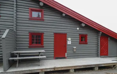 a gray cabin with red doors and a bench at Gorgeous Apartment In Trysil With Sauna in Trysil