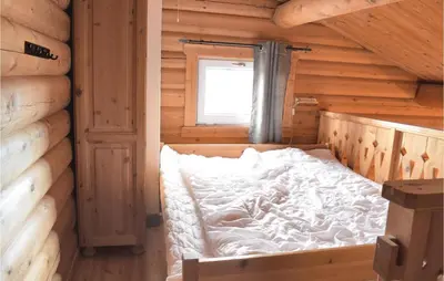 a bedroom with a bed in a log cabin at Gorgeous Apartment In Trysil With Sauna in Trysil
