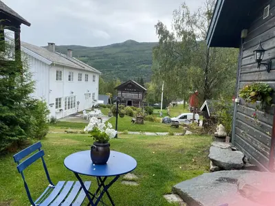a table and a chair in the yard of a house at Hesla Farm in Gol