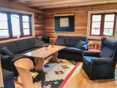a living room with couches and a table and chairs at Tjonnas Farm Stay in Sauland
