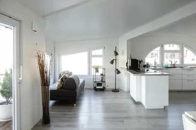 a white kitchen and living room with a couch at Floating Villa Bergen in Bergen