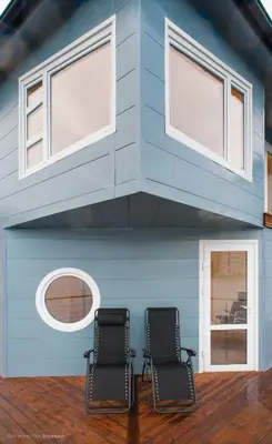 two chairs in front of a house with windows at Floating Villa Bergen in Bergen
