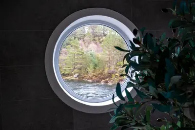 a round window with a view of a river at Floating Villa Bergen in Bergen